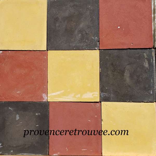 Anciens carreaux de ciment noir jaune brun rouge posés en damier