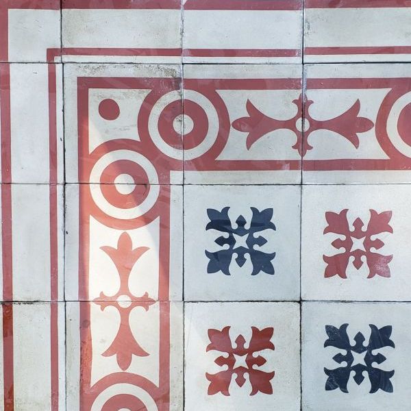 Carrelage ancien en ciment avec motif floral et frise géométrique
