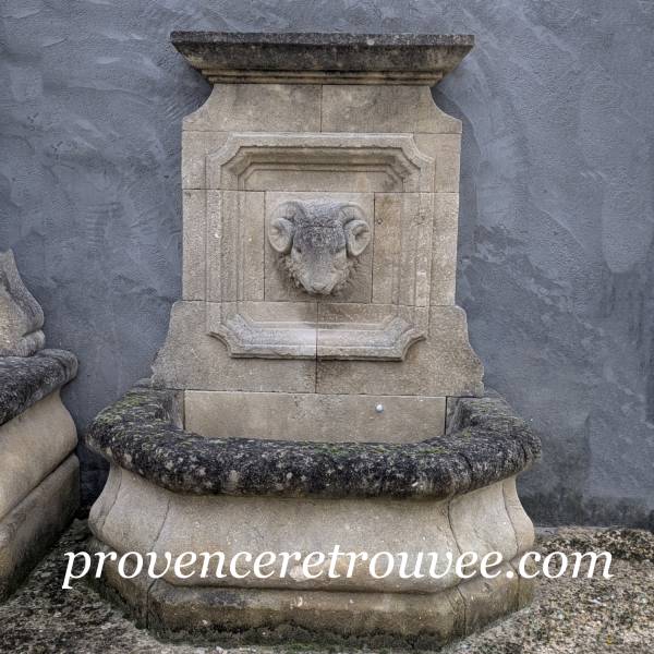 Fontaine ancienne en pierre tête de belier sculptée