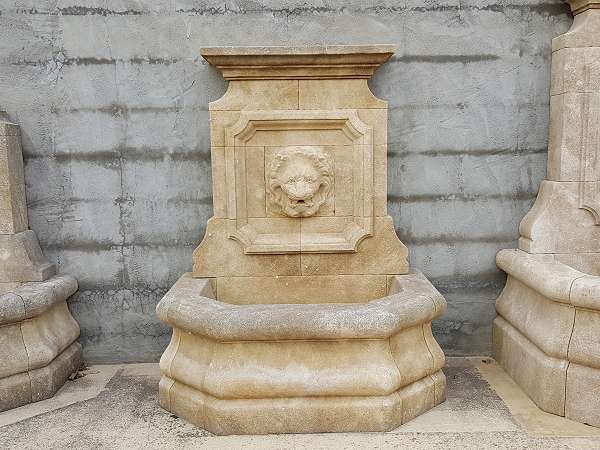 Fontaine d'extérieur en pierre avec lion sculpté