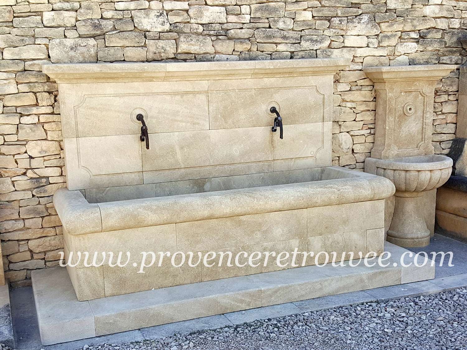 Large fontaine de village en pierre naturelle Arles fon20-256 : Avec son fronton rectangulaire à double sortie d'eau, cette large fontaine en pierre naturelle pleine de charme est l'élément idéal pour donner à votre jardin l'âme authentique des villages de Provence. Bassin 210x75cm posé sur marche 256x100cm.