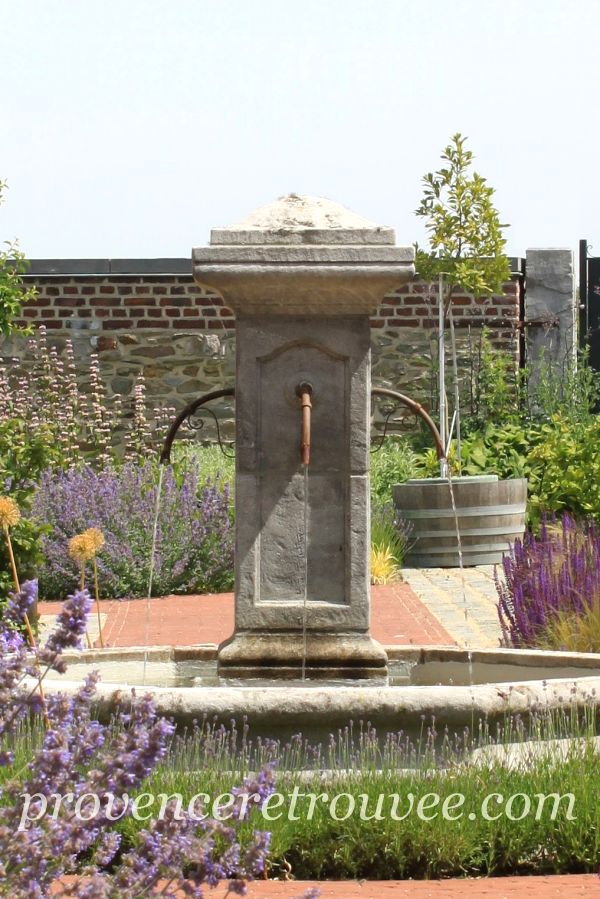 Fontaine centrale en pierre naturelle installée dans un jardin de style provençal