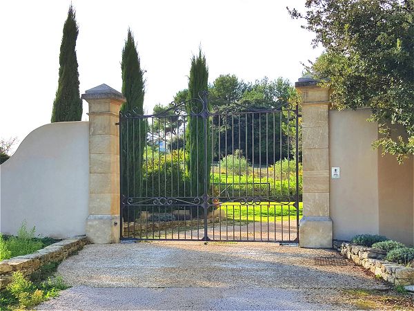 Cette demeure provençale a été cloturée avec des piliers en pierre et un portail en fer forgé de 3m50 de large par 3m de haut.
