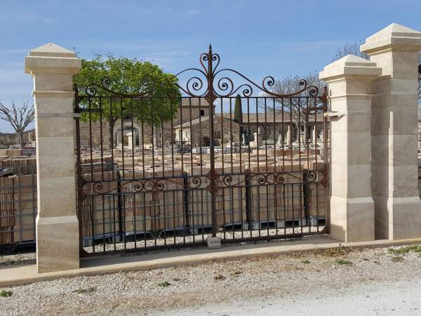 Piliers en pierre avec chapiteau pointe et portail en fer provençal
